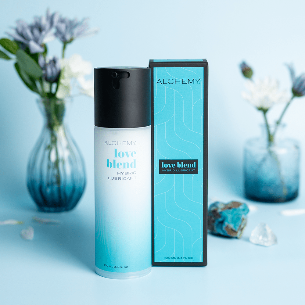 Alchemy Love Blend: Hybrid Personal Lubricant bottle and box with plants in vases and blue background