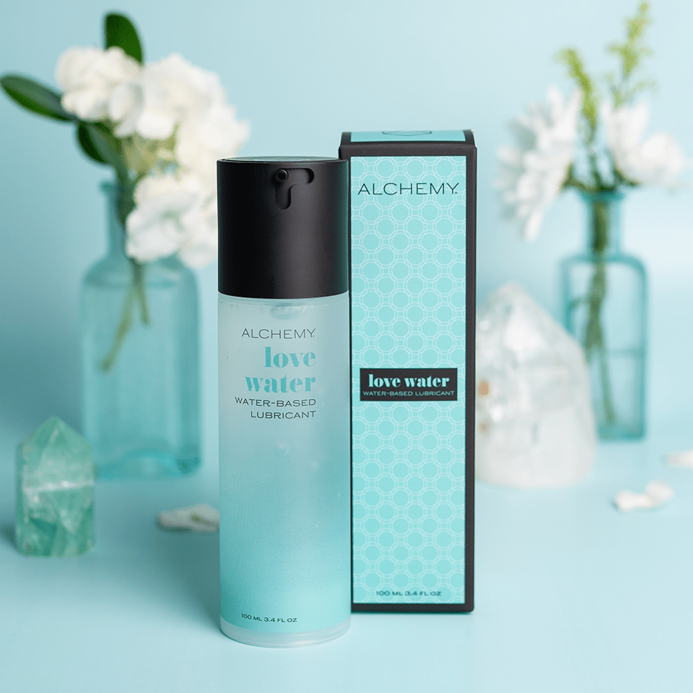 Alchemy Love Water: Water-Based Personal Lubricant bottle and box with plants in vases and aqua background