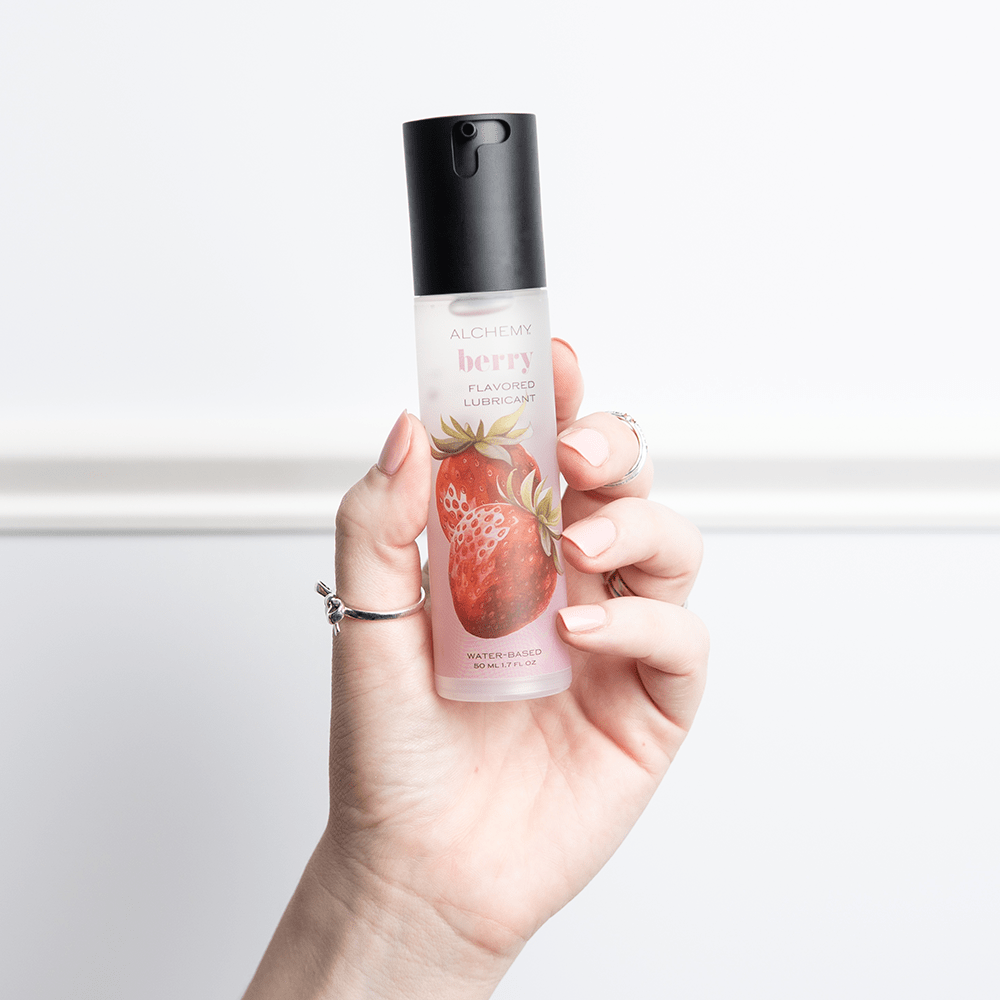 Alchemy Indulge: Strawberry Flavored Personal Lubricant bottle in woman's hand
