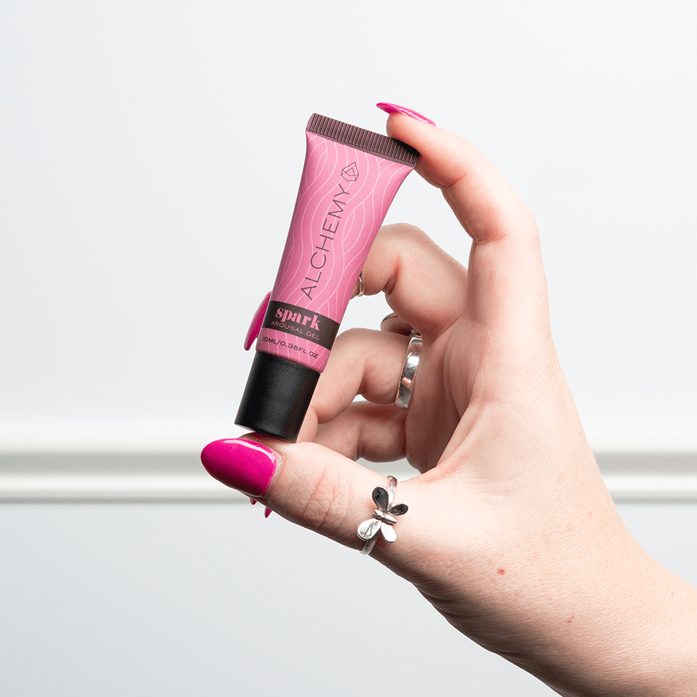 Woman's hand holding Alchemy Spark Female Arousal Gel 1oz tube