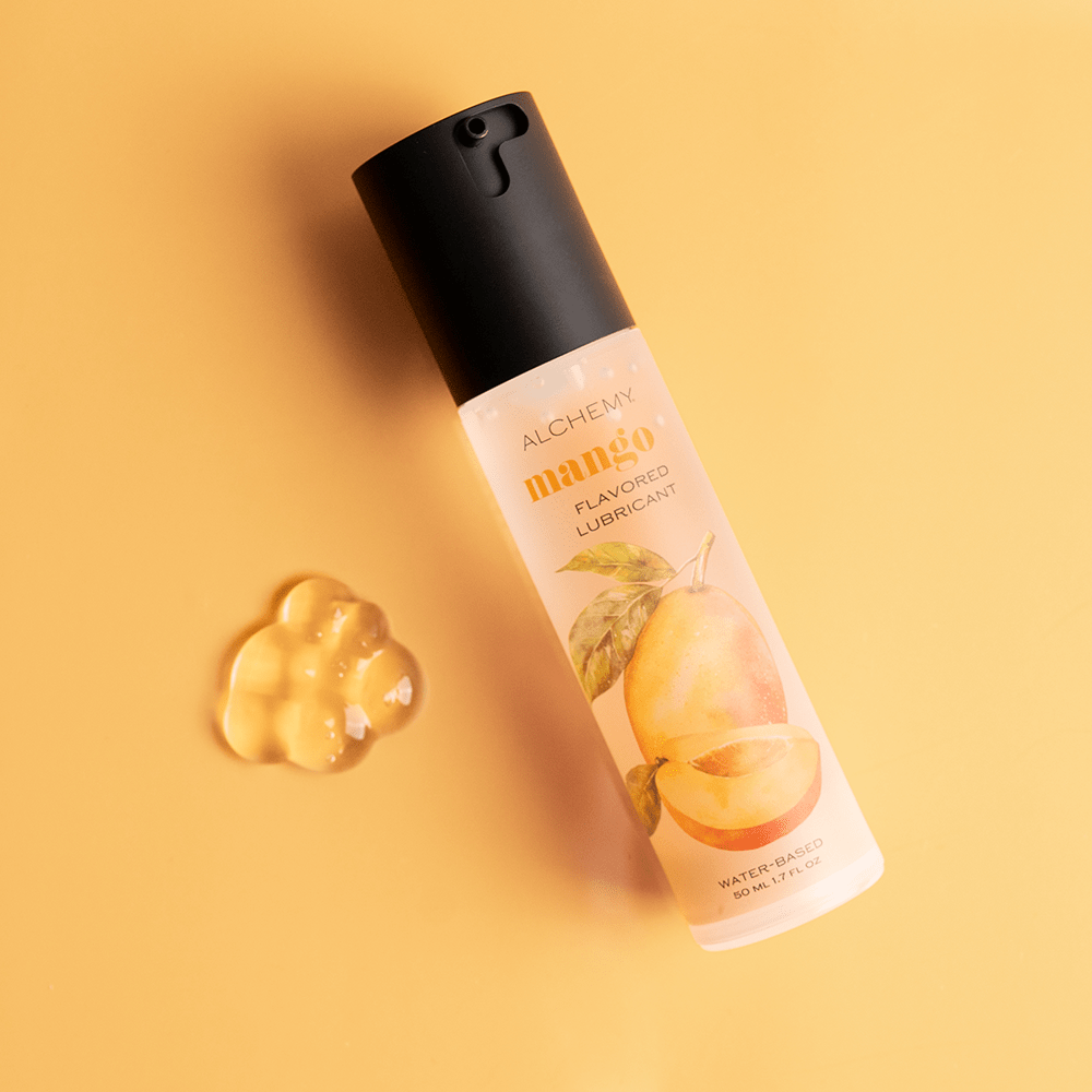 Alchemy Indulge: Mango Flavored Personal Lubricant bottle with liquid droplet