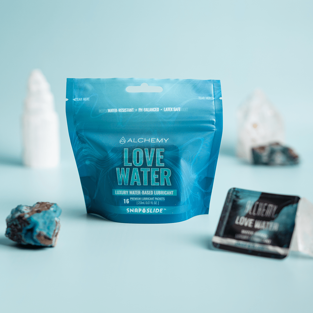 Alchemy Love Water Water-Based Snap + Slide Single-Use Personal Lubricant Packets packaging with crystals