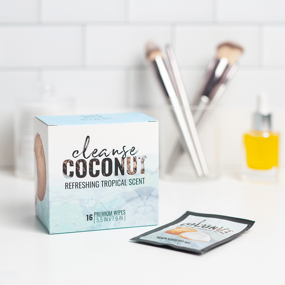 Alchemy Cleanse Coconut Scented Wipes box on white bathroom counter with makeup applicators in the background