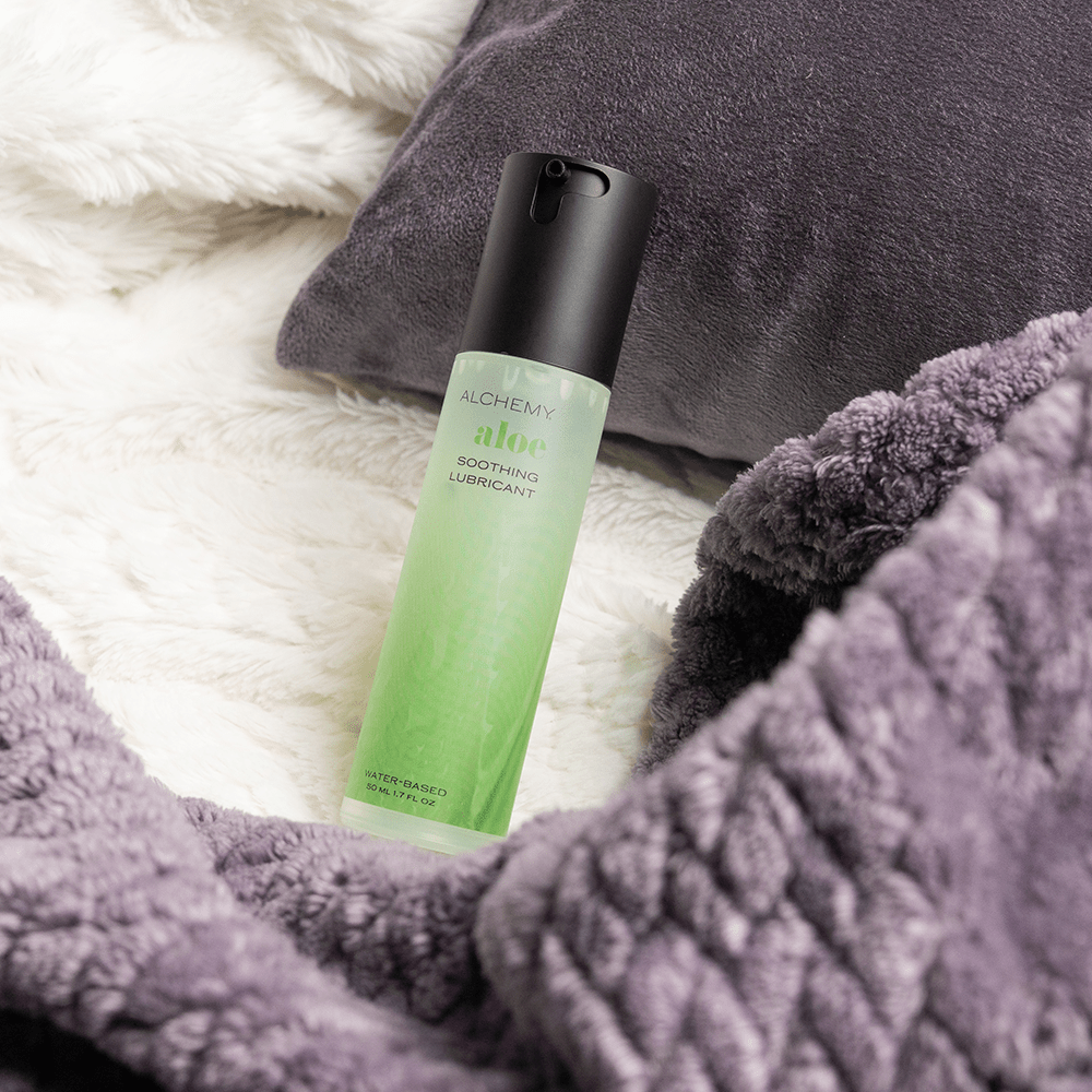 Alchemy Aloe: Hydrating Water-Based Personal Lubricant bottle on bed blanket