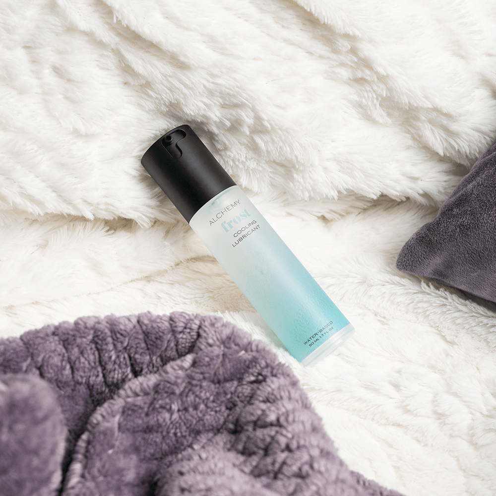 Alchemy Frost: Water-Based Cooling Personal Lubricant bottle on bed blanket