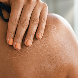 Alchemy Fever: Water-Based Warming Personal Lubricant – close-up of woman's hand on her shoulder