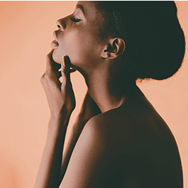 Alchemy Fever: Water-Based Warming Personal Lubricant – woman with her hand on her chin with dramatic lighting