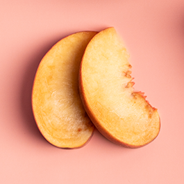 Top view of peach slices on a pink background