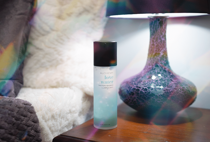 Alchemy Love Water: Water-Based Personal Lubricant bottle on nightstand
