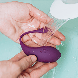 Alchemy Love Water: Water-Based Personal Lubricant  – easy to clean: person's hands rinsing vibrator in a sink