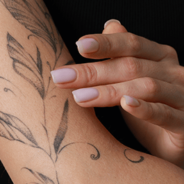 Natural feel: tattooed woman applying product to the skin of her arm