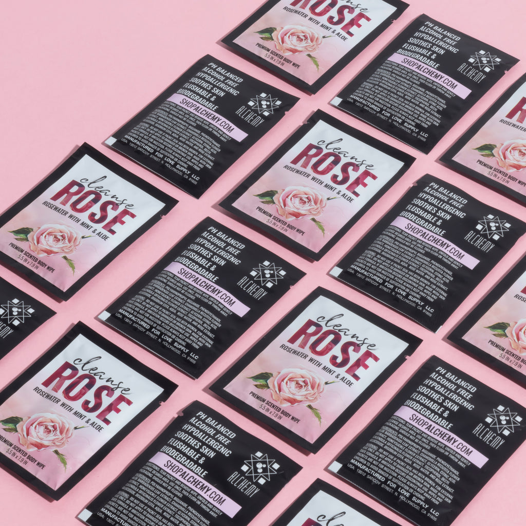 Cleanse by Alchemy® Refreshing Rosewater with Mint and Aloe Body Wipe Single Packets with Front and Back View on Pink Background