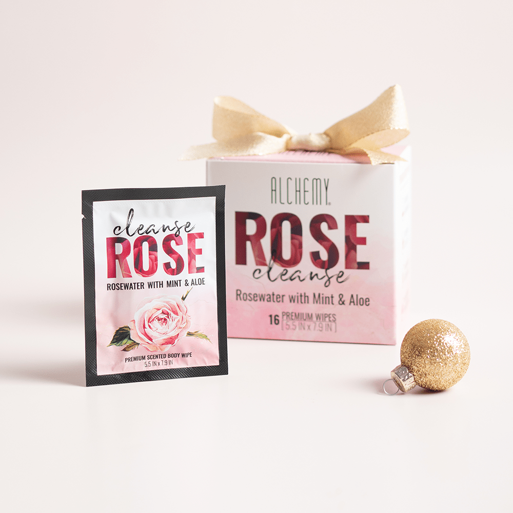 Alchemy Cleanse Rosewater Scented Wipes with holiday gift boxes, ornaments, and light pastel background