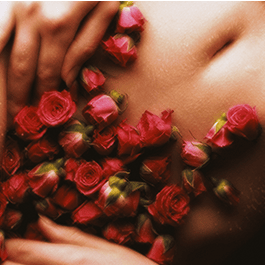 Alchemy Rosebud: Luxury Air-Pulse Massager – woman's torso and hands with small red roses